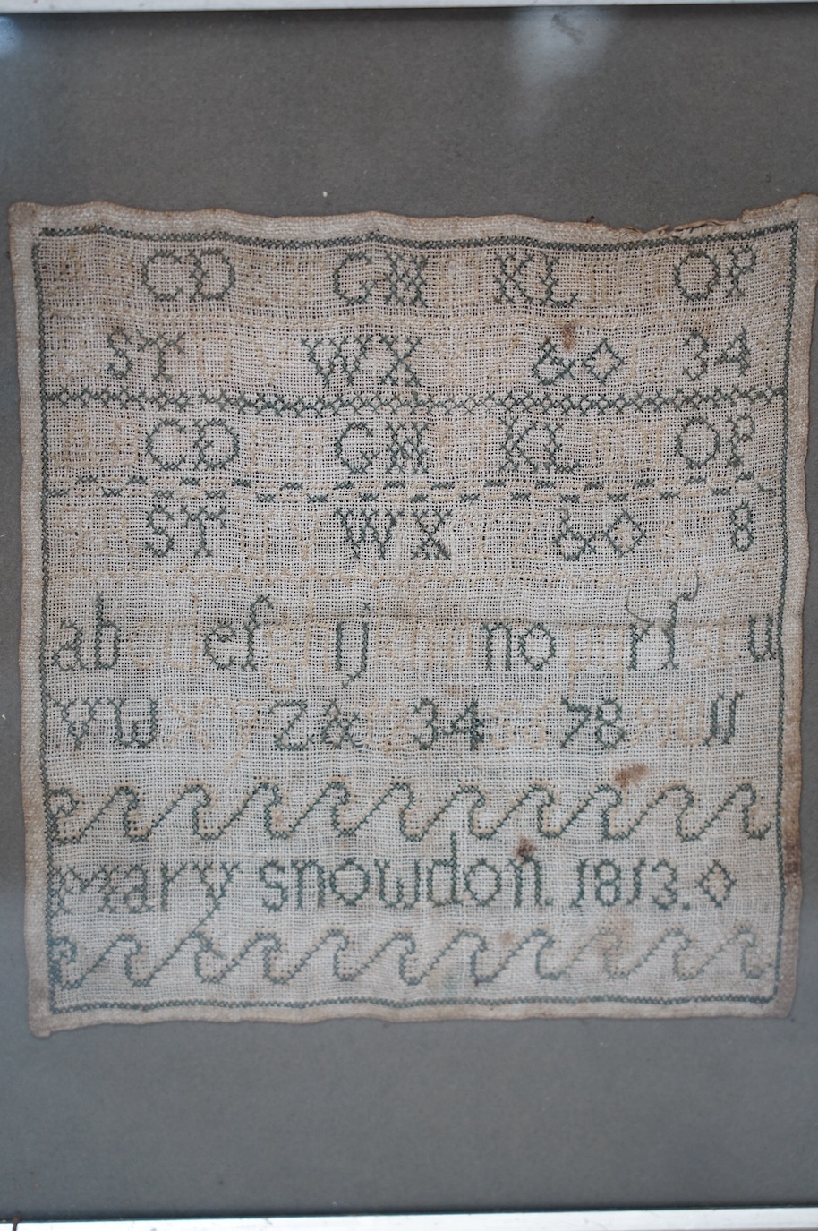 An early 19th century alphabet sampler worked by Mary Snowdon 1813, 21 x 19cm. Condition - poor